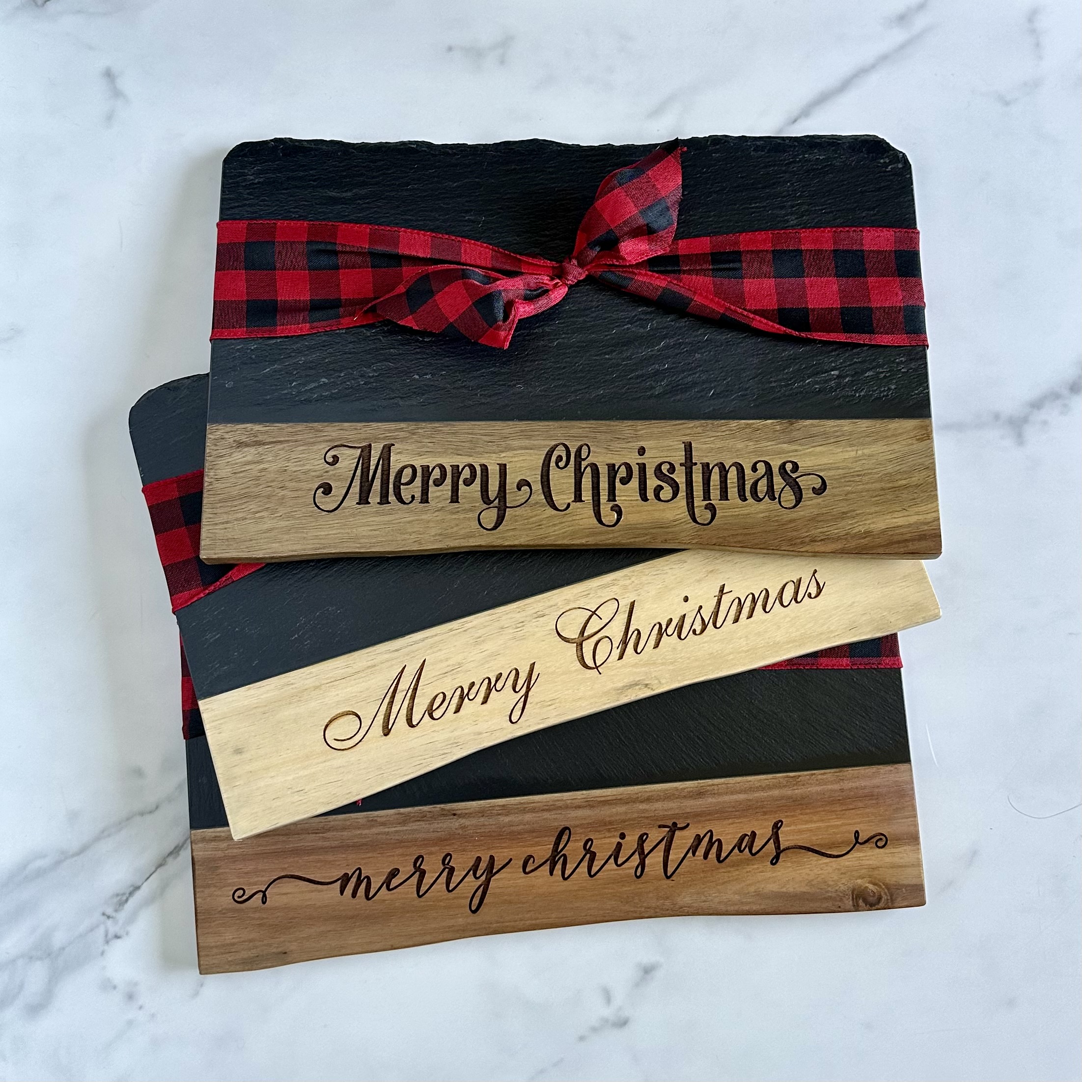 Stacked slate and wood boards with Merry Christmas engraving